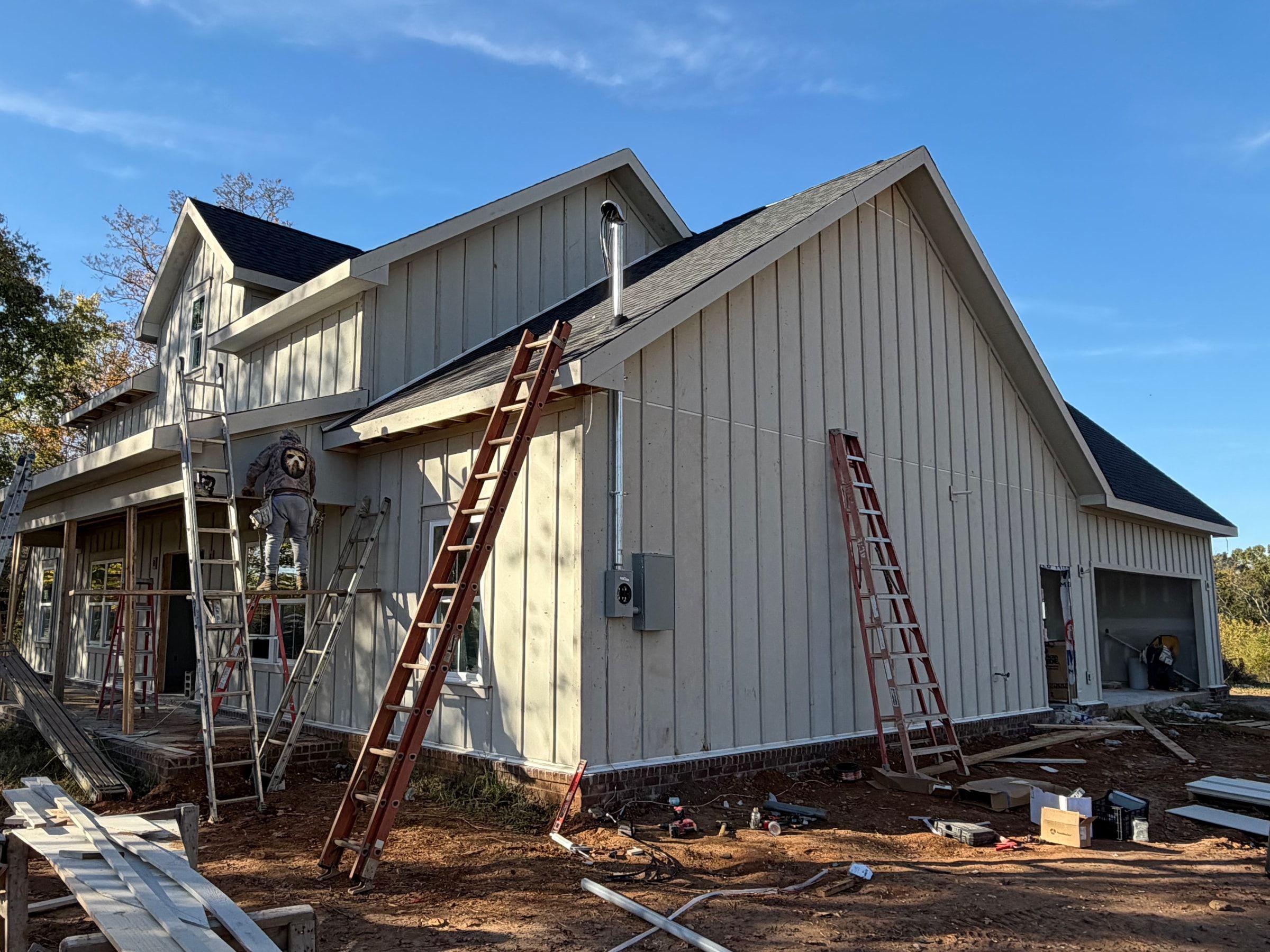 Crew installing board and batten siding on a new home
